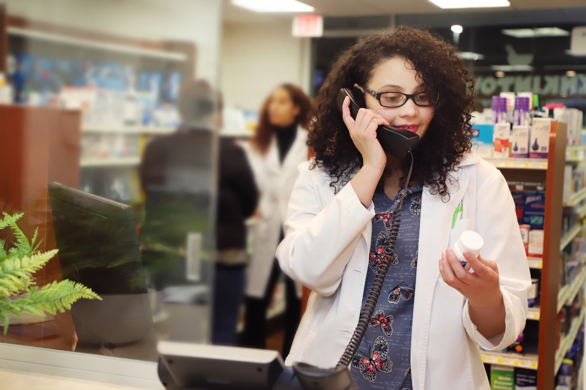 Jenkintown Pharmacy pharmacist on the phone reviewing a prescription at the counter